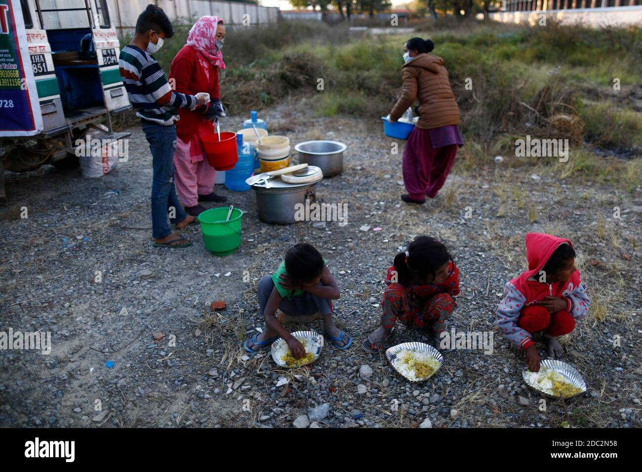 Kathmandu, Nepal. 18 Nov 2020. I fratelli più giovani mangiano pasti caldi gratuiti distribuiti dal gruppo dei 100 anni dopo che il luogo per la distribuzione di cibo libero è stato spostato da Khula Manch a Thapathali a Kathmandu, Nepal mercoledì 18 novembre 2020. Successivamente, la città metropolitana di Kathmandu ha annunciato di interrompere la distribuzione di cibo gratuito nello spazio aperto dove più di 600 persone sono state nutrite ogni giorno, opponendosi a problemi di salute. Il gruppo ha iniziato la campagna di alimentazione da aprile a coloro che sono rimasti vulnerabili dalla crisi del Covid-19. Credit: ZUMA Press, Inc./Alamy Live News Foto Stock