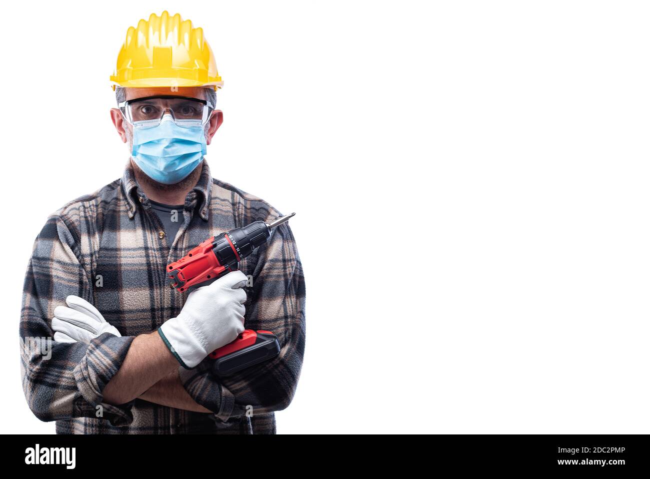 Falegname isolato su sfondo bianco, indossa casco, occhiali, guanti in pelle e maschera chirurgica per prevenire l'infezione da coronavirus. Prevenzione Pa Foto Stock