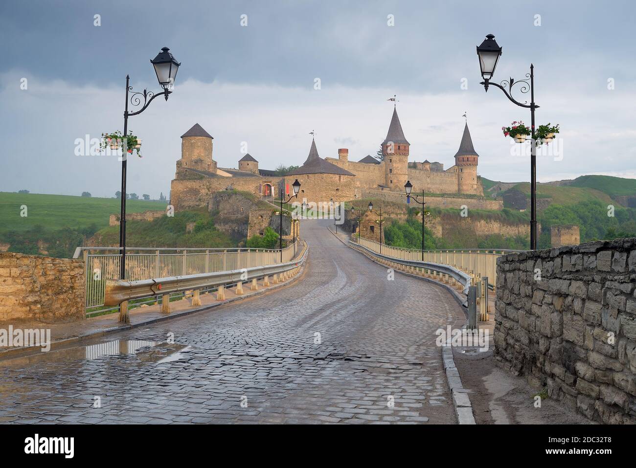 Strada che conduce al castello medievale. Fortificazione punto di riferimento storico. Paesaggio urbano al mattino. Kamenetz-Podolsk, Ucraina, Europa Foto Stock