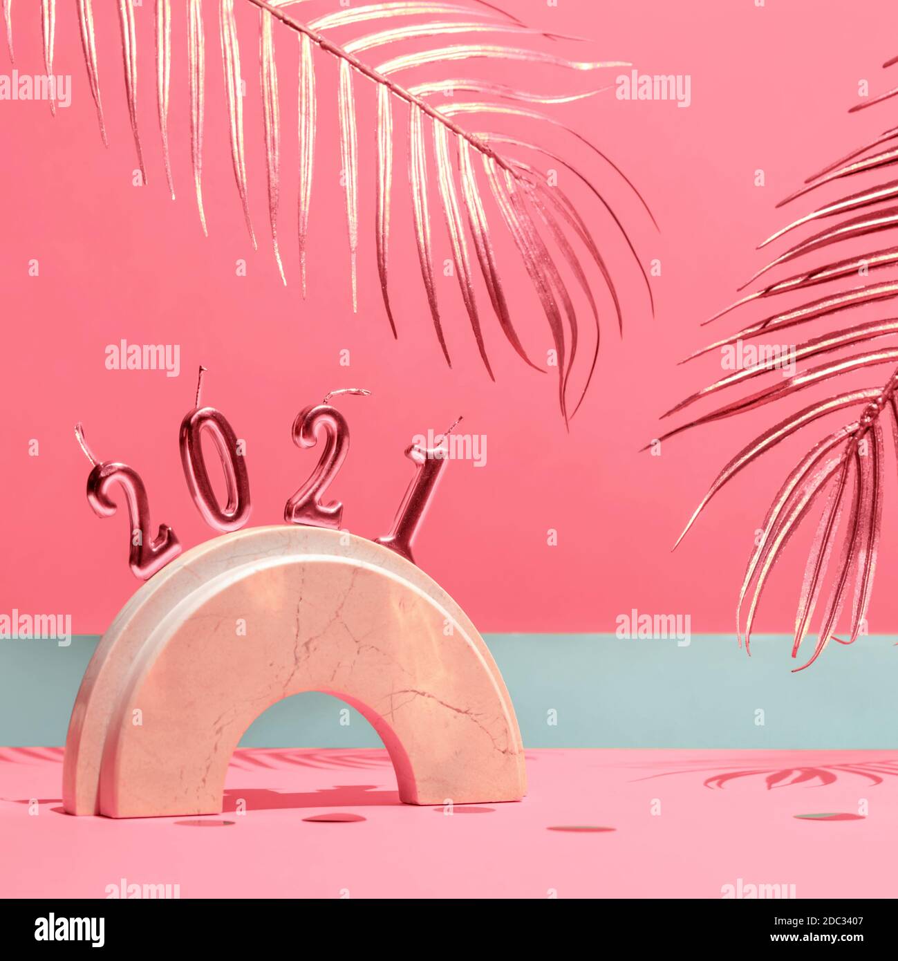 Candele d'oro con il nuovo anno 2021 sull'arco di marmo, foglie di palma, confetti su sfondo giallo con l'orizzonte. Tendenza festiva ancora vita. Foto Stock