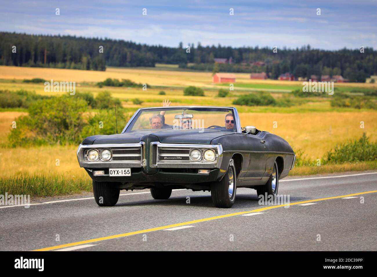 Tre uomini che si divertono con un viaggio sulla classica auto nera Pontiac Bonneville con una crociera in auto Maisemaruise 2019. Vaulammi, Finlandia. 3 agosto 2019. Foto Stock
