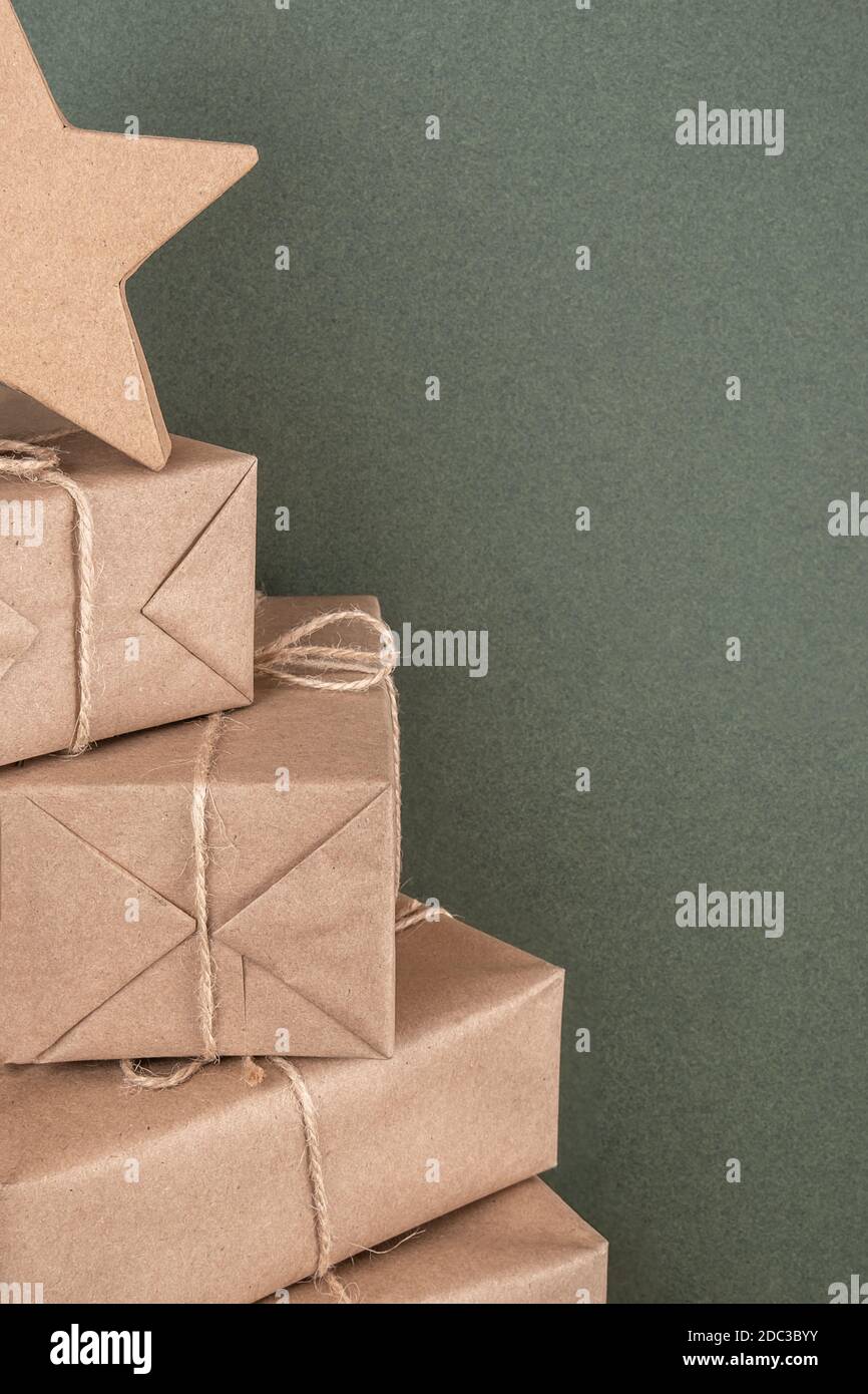 Albero di Natale. Scatole in carta artigianale su sfondo verde, primo piano. Concept NATALE o Capodanno. Vista frontale Copia spazio. Foto Stock