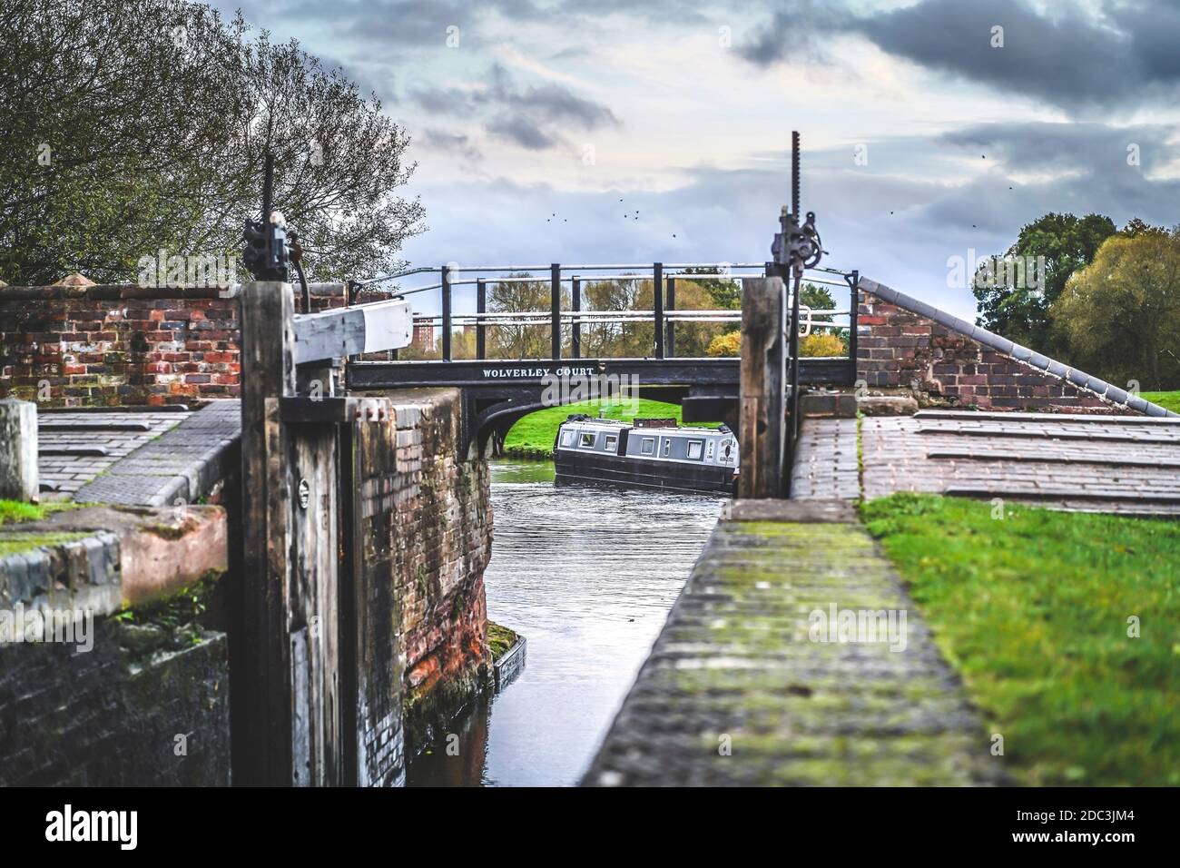 Barca stretta vista attraverso le porte aperte del canale UK lock in una giornata autunnale con cielo coperto. Foto Stock