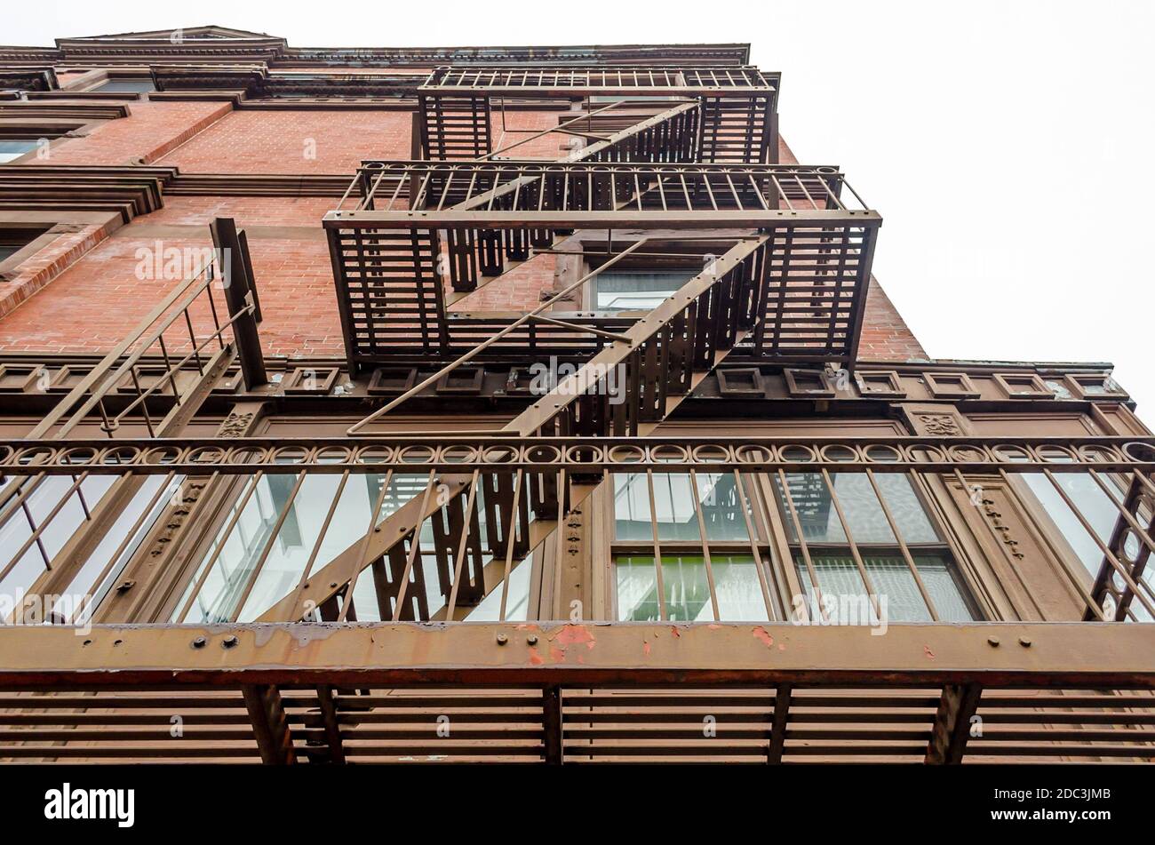 Vista ad angolo basso dei tipici appartamenti di New York City con scale di fuga dal fuoco a Manhattan, New York, Stati Uniti Foto Stock