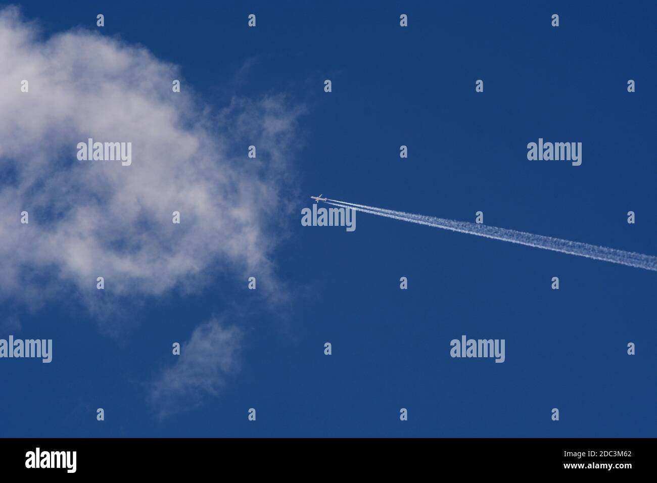 Un aereo a getto di passeggero lascia una lunga pista di vapore o contrail nella relativa scia mentre vola sopra il sud-ovest americano. Foto Stock
