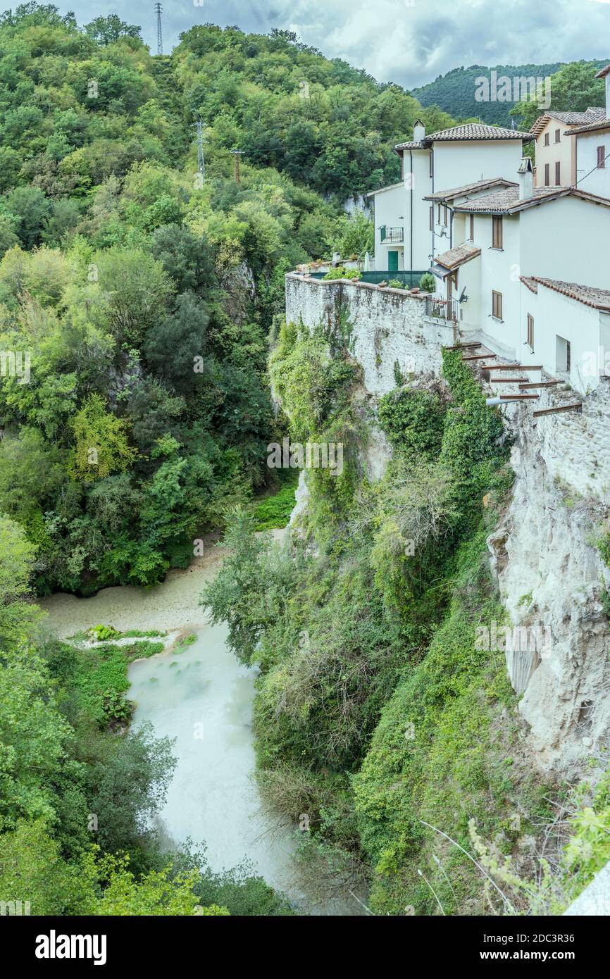 Paesaggio urbano con vecchie case sull'orlo dello sbalzo sul fiume Nera, girato in luce luminosa a Triponzio, Perugia, Umbria, Italia Foto Stock