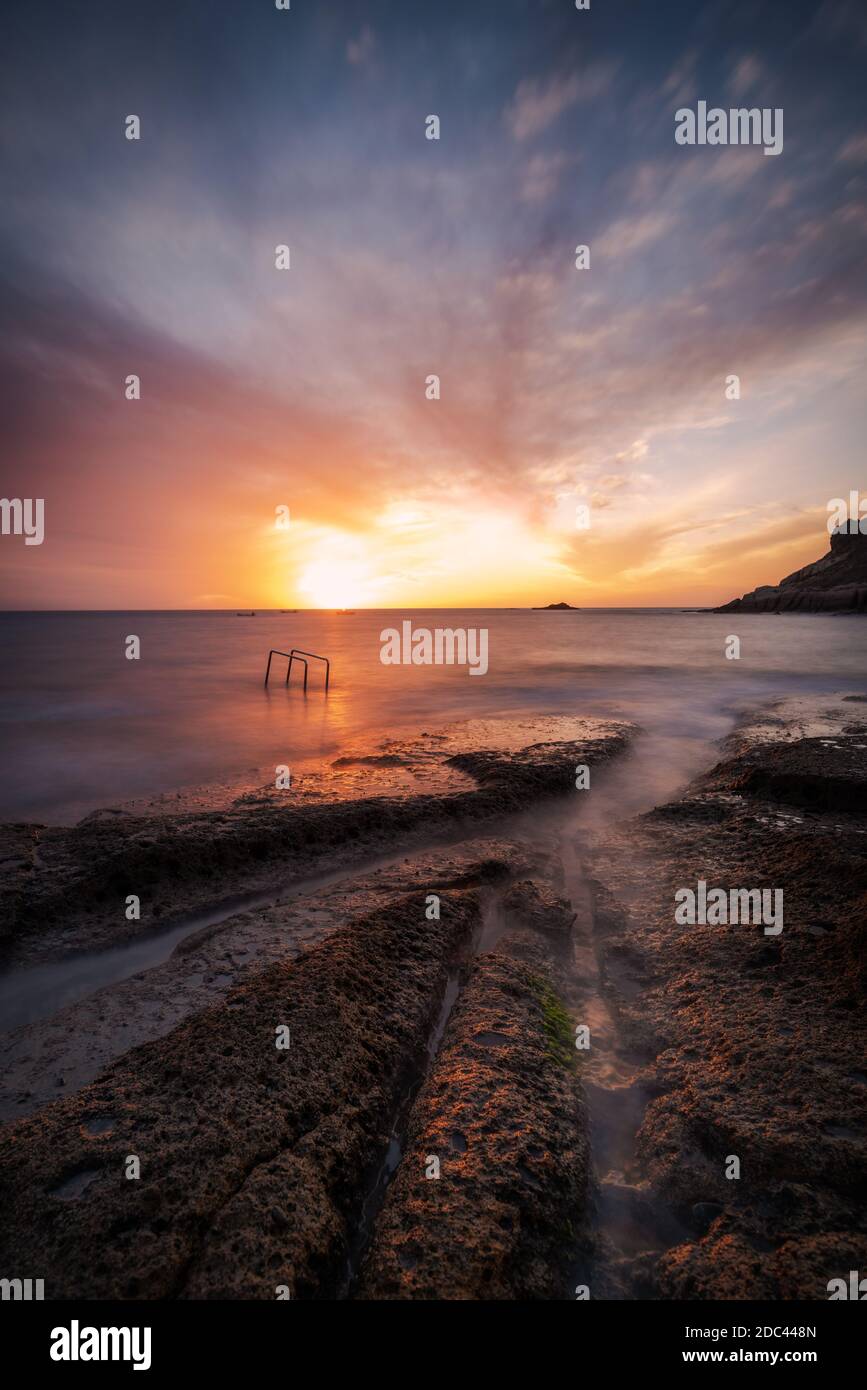 paesaggio montano con nuvole e colori caldi del tramonto Foto Stock