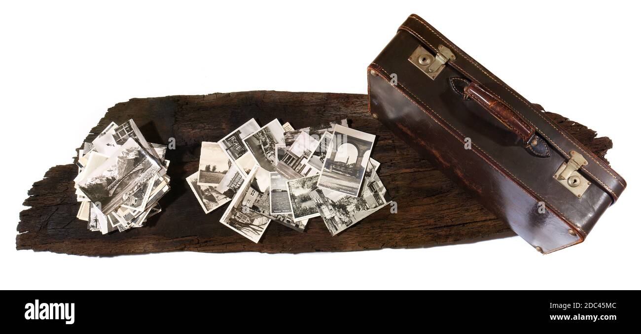 Vecchie cartoline nostalgiche su una tavola vintage wodden con valigia Foto Stock