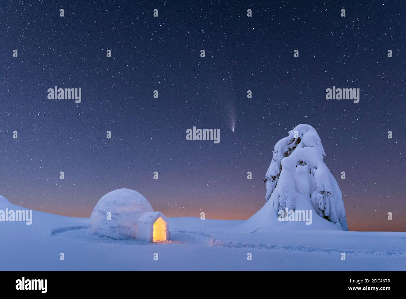 Neve igloo luminoso dall'interno nelle montagne invernali. Cielo stellato con cometa sullo sfondo Foto Stock