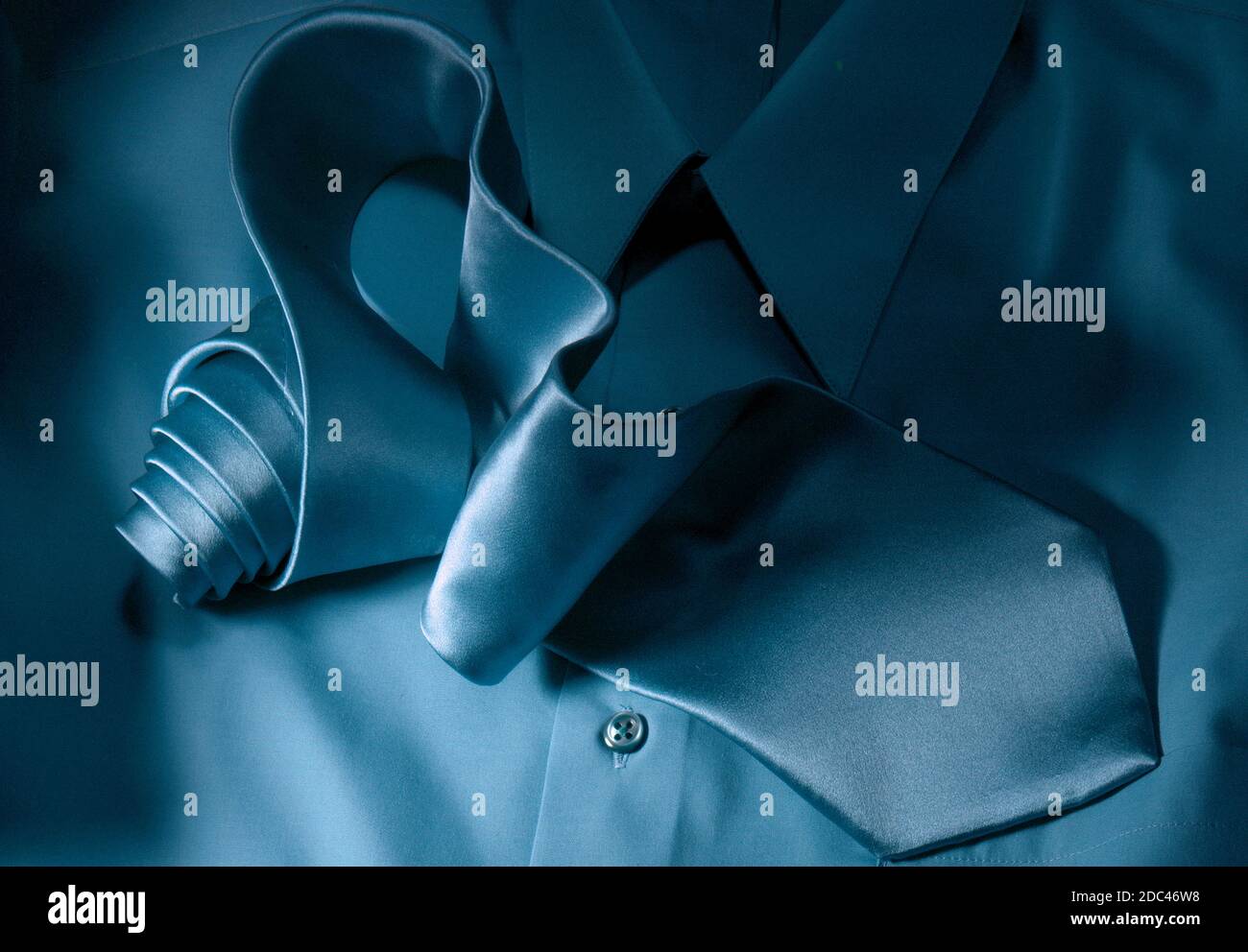 Cravatta e camicia in seta. In questa fotografia orizzontale, la fascetta viene arrotolata e scorre attraverso il telaio. Illuminazione direzionale molto forte. Tie è un eroe. Foto Stock