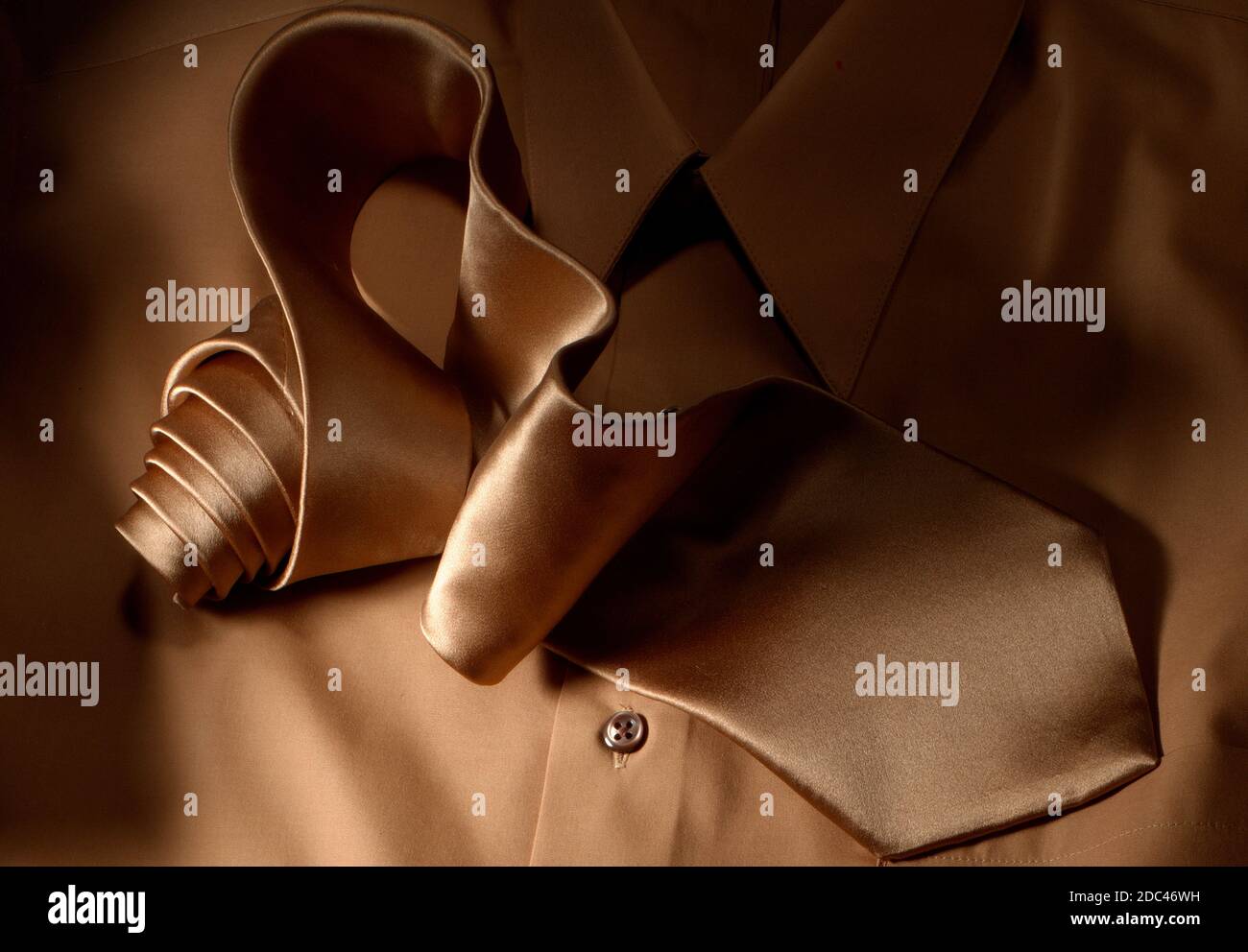 Cravatta e camicia in seta. In questa fotografia orizzontale, la fascetta viene arrotolata e scorre attraverso il telaio. Illuminazione direzionale molto forte. Tie è un eroe. Foto Stock