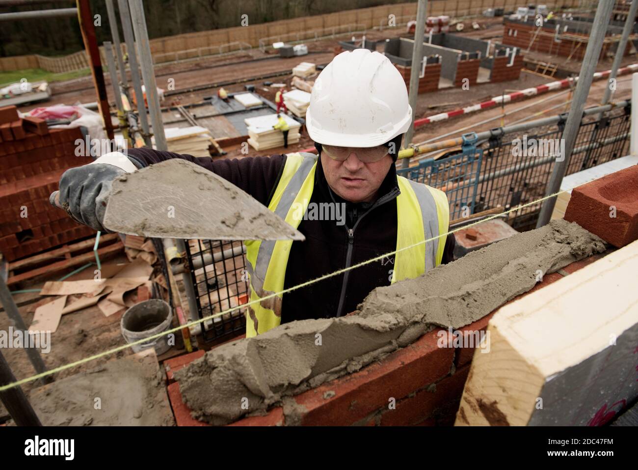 Muratore al lavoro su un sito di alloggi nel Regno Unito Foto Stock
