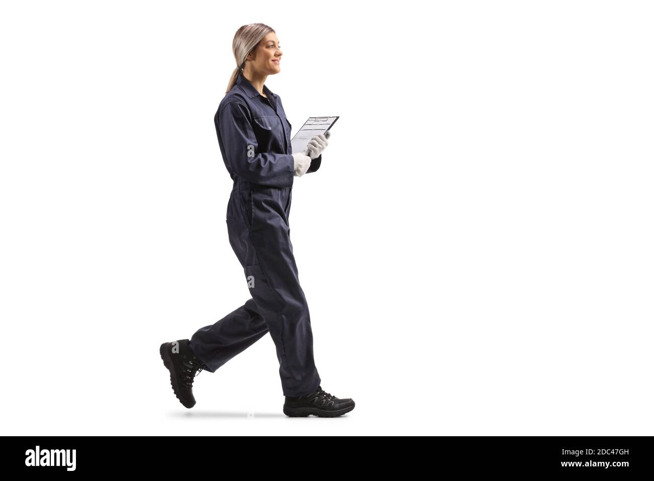 Foto di profilo a lunghezza intera di una lavoratrice in un camminata uniforme isolata su sfondo bianco Foto Stock