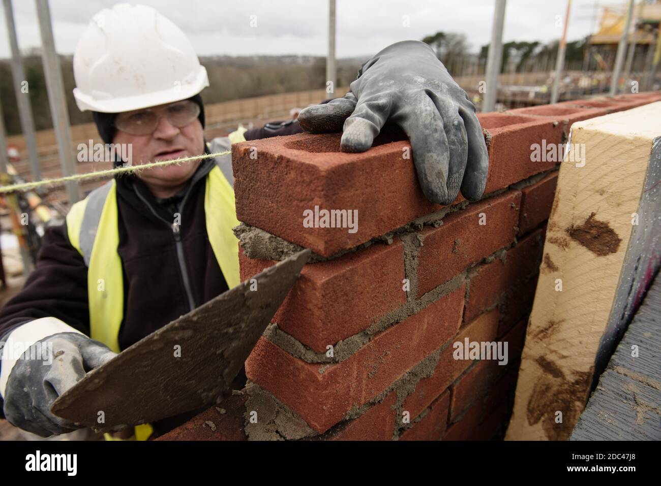 Muratore al lavoro su un sito di alloggi nel Regno Unito Foto Stock