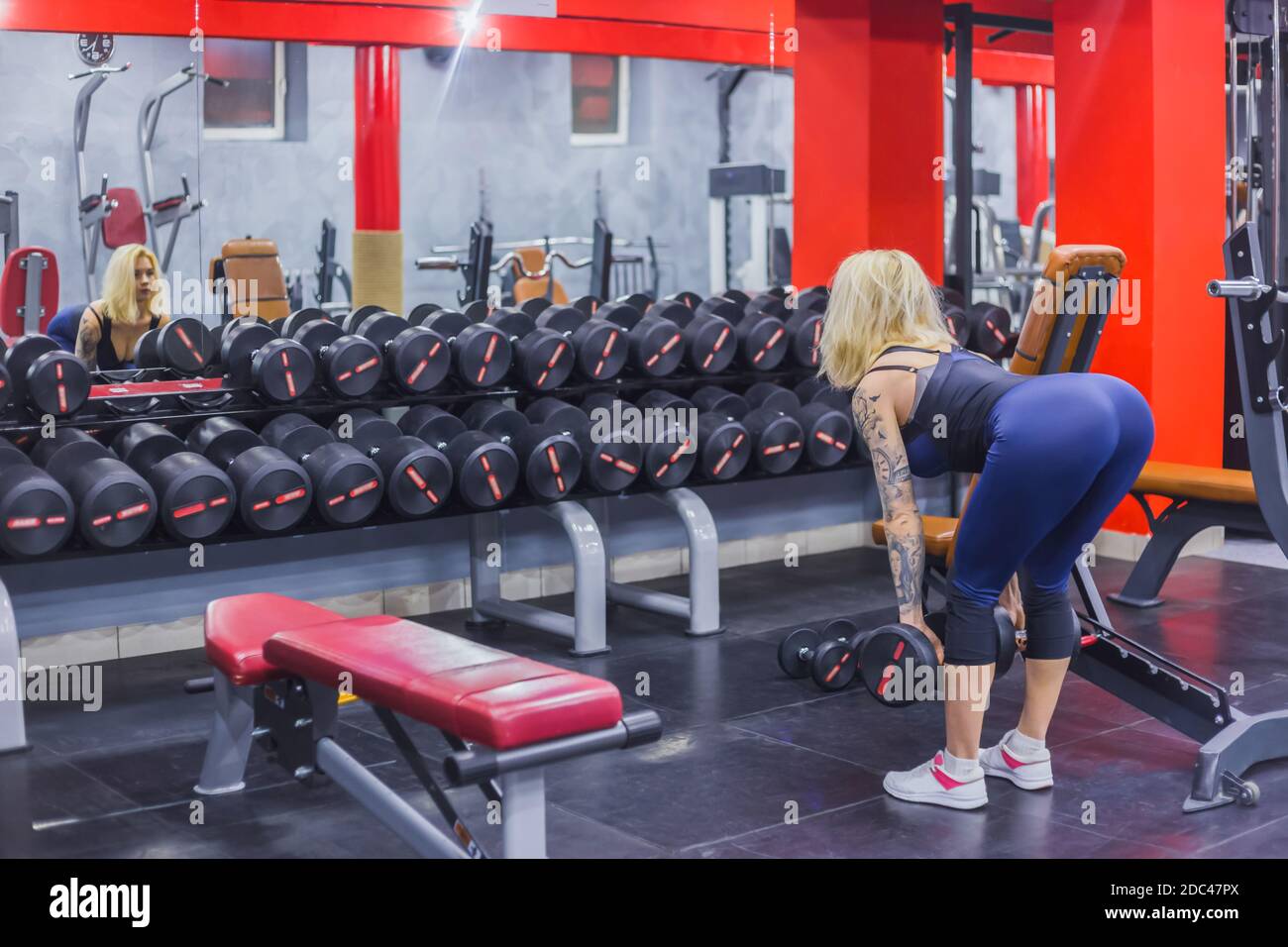 Atletica Giovane donna il sollevamento pesi in palestra Foto Stock