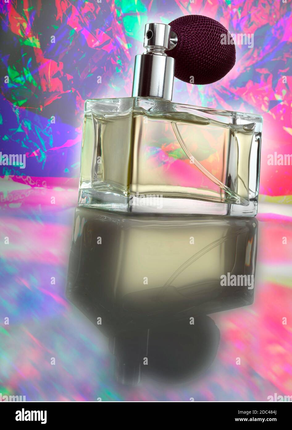 Flacone di profumo in vetro con spray a bulbo atomizzatore. Fotografato a un angolo basso con un'illuminazione spettacolare e uno sfondo psichedelico e colorato. Foto Stock