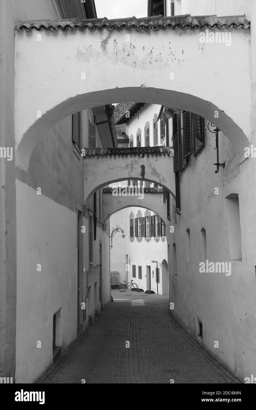 Città storica di Merano, Bolzano, Trentino Alto Adige, Italia. Una strada con archi. Bianco e nero Foto Stock