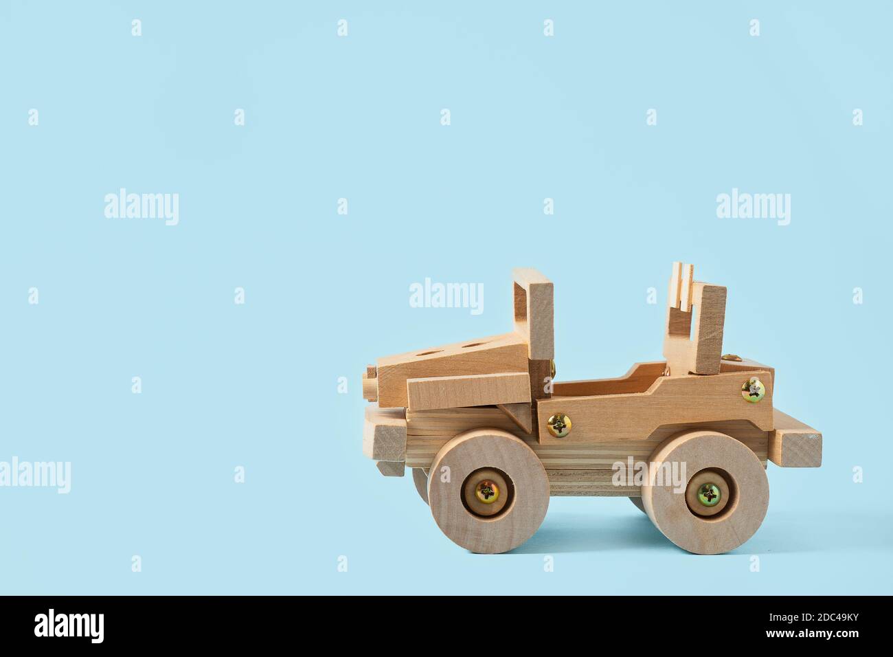 Giocattolo in legno per auto su sfondo blu con spazio per la copia testo Foto Stock