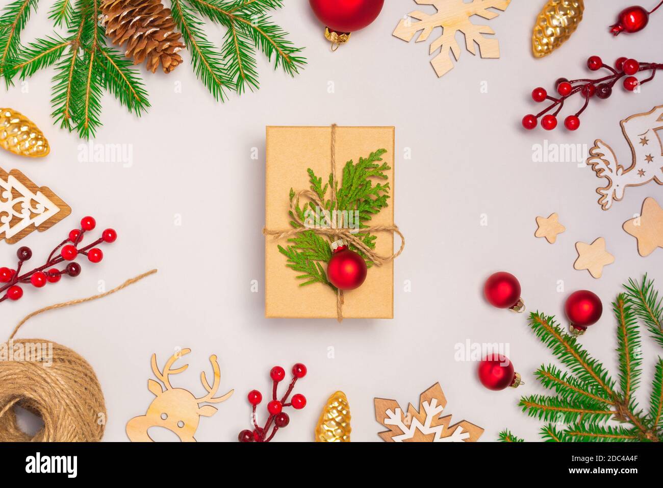 Sfondo bianco con baubles e presenta regalo in scatola artigianale con decoratoins. Natale senza sprechi, Capodanno, giorno del Ringraziamento. Disposizione flay, vista dall'alto Foto Stock