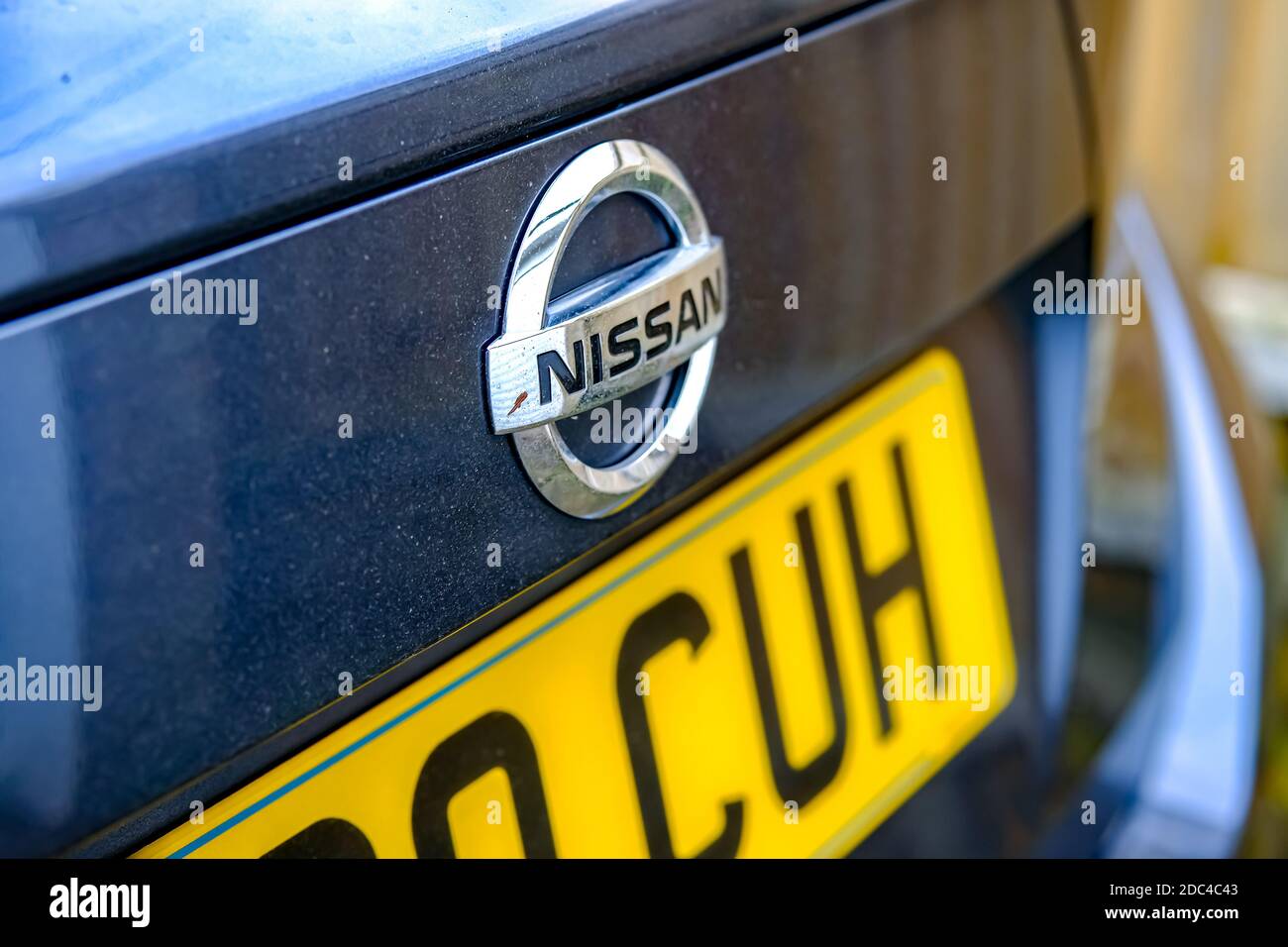Norwich, Norfolk, Regno Unito – Novembre 17 2020. Una foto illustrativa di una messa a fuoco selettiva, stretta e poco profonda su un badge Nissan sullo sportello del bagagliaio di un Nissa grigio Foto Stock