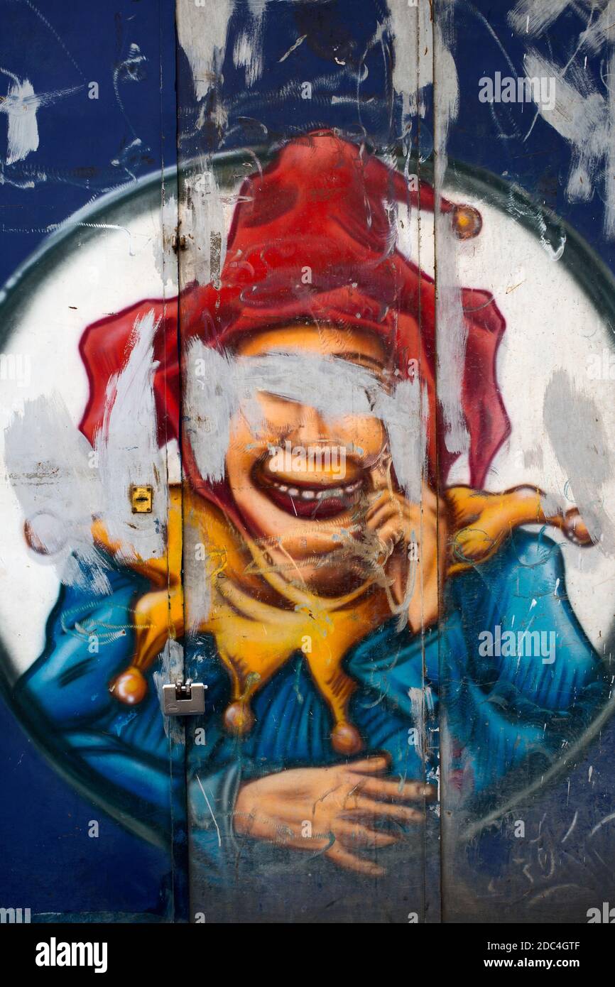 Murale rovinato su una porta che rappresenta un jester jolly scherzatore Foto Stock