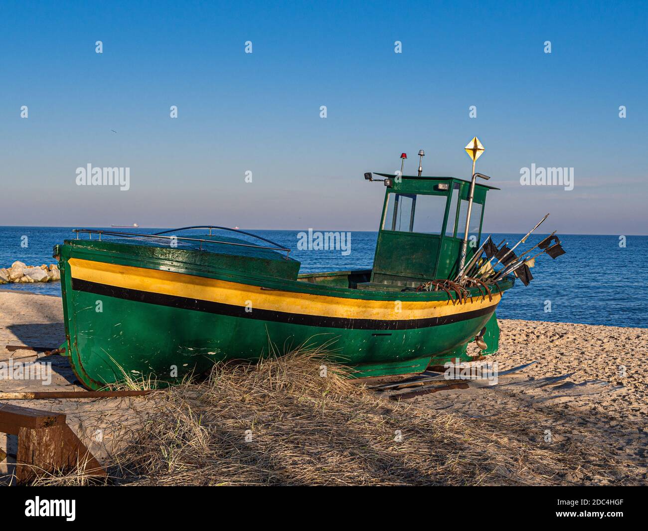 Una vecchia barca da pesca verde. La barca è tirata fuori al mare. Mar Baltico. Foto Stock