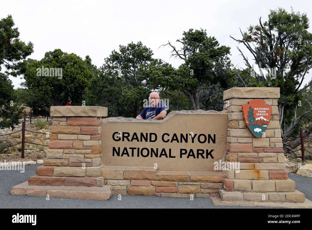 Il 27 ottobre 2016, un turista si erge accanto al cartello del Grand Canyon National Park dal South Rim. Foto Stock