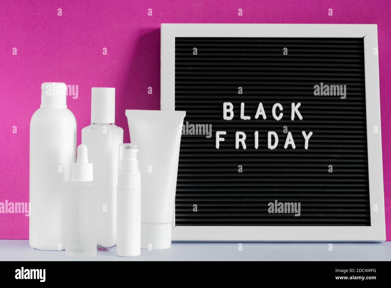 Mockup cosmetico di bellezza del Black Friday. Simulate il prodotto per la cura della pelle. Lavagna con iscrizione Black Friday. Crema lozione spray siero bottiglie di olio. Pelle Foto Stock