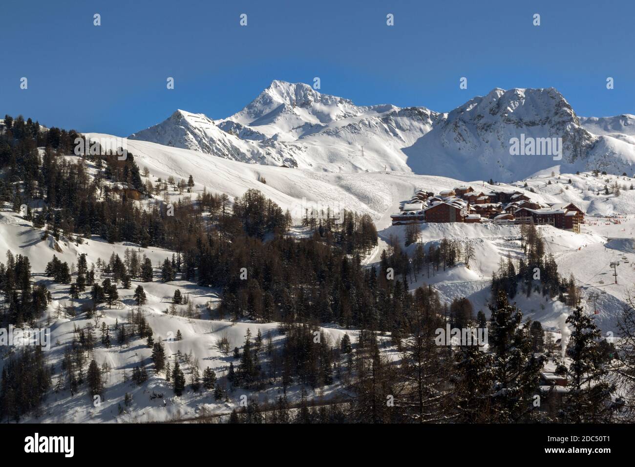 LA PLAGNE, FRANCIA - 13 FEBBRAIO 2018: Vista sulle montagne e alcuni chalet in un pomeriggio di sole inverno Foto Stock