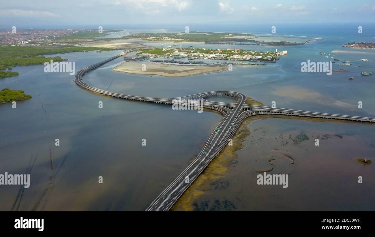 Vista aerea della strada a pedaggio Bali Mandara sul mare. Auto, ponte moto attraverso il Golfo di Benoa che collega Denpasar città e Sud Kuta, Nusa Dua e. Foto Stock