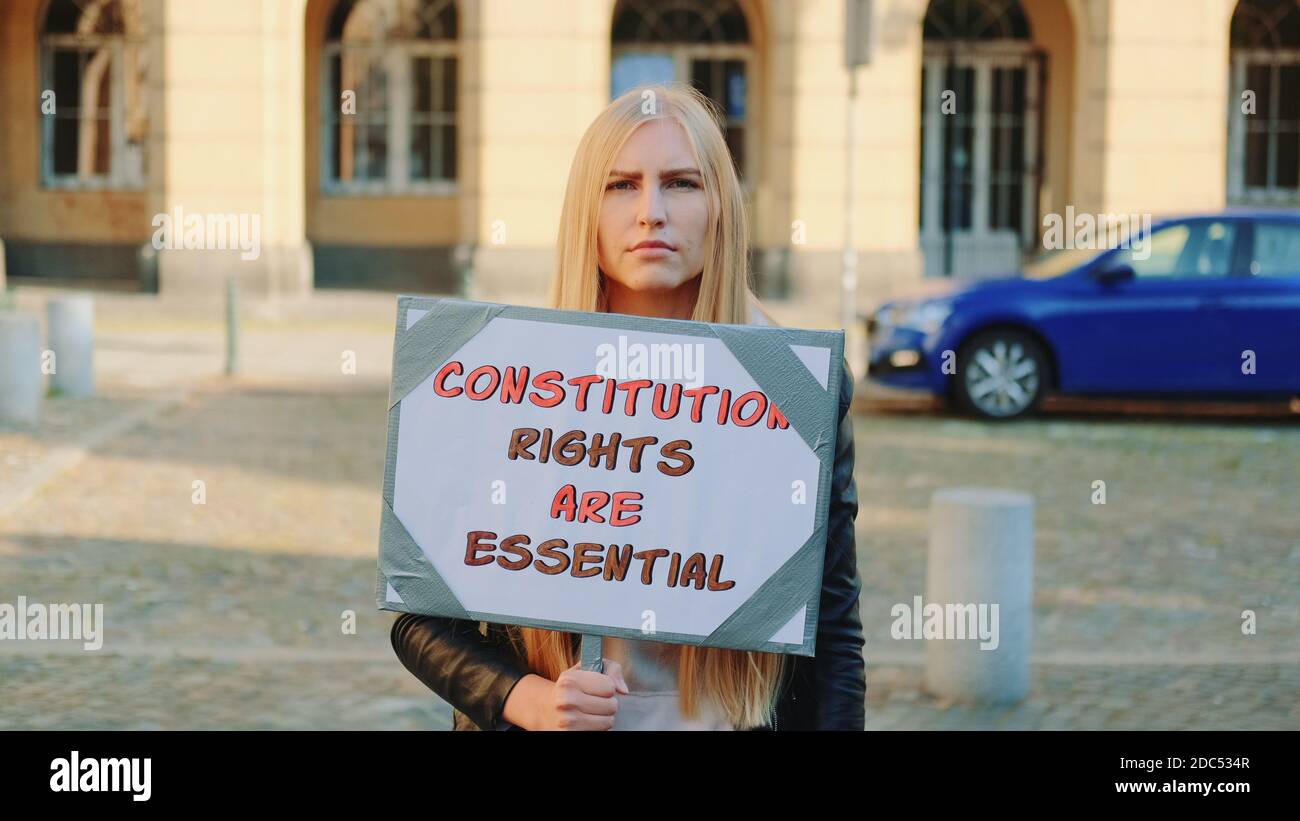 Protesta a piedi: Donna che sostiene la tutela dei diritti costituzionali. Tiene la bandiera e va sulla strada. Foto Stock