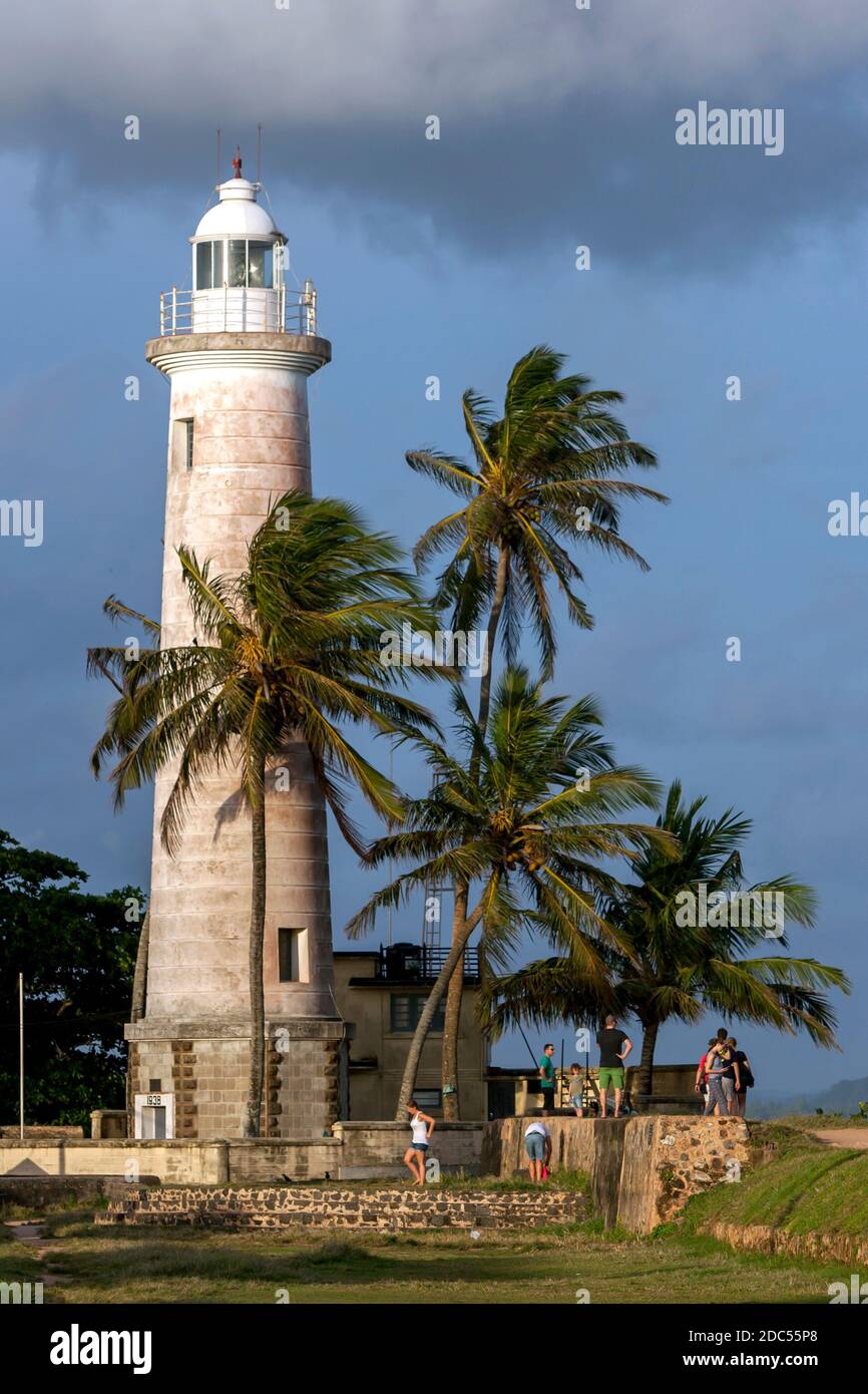 I turisti si riuniscono alla base del faro di Point Utrecht Bastion, situato all'interno del vecchio forte olandese a Galle, nello Sri Lanka. Foto Stock