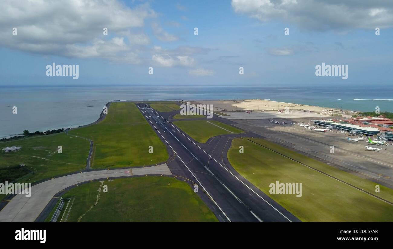 Pista all'aeroporto internazionale Denpasar di Bali, Indonesia. Pista che raggiunge l'oceano. Vista aerea dell'aeroporto di Ngurah Rai Foto Stock