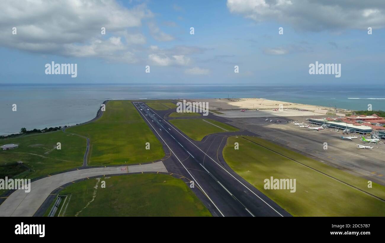 Pista all'aeroporto internazionale Denpasar di Bali, Indonesia. Pista che raggiunge l'oceano. Vista aerea dell'aeroporto di Ngurah Rai Foto Stock
