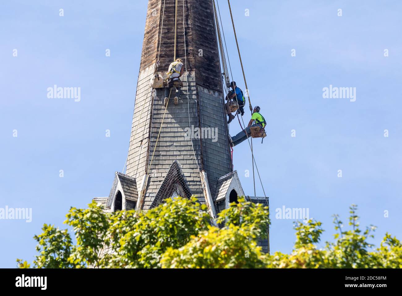 I lavoratori riparano il campanile della Chiesa di San Giovanni a Burlington, Iowa diverse settimane dopo gravi tempeste e dereco che hanno colpito gli stati del Midwest. Foto Stock