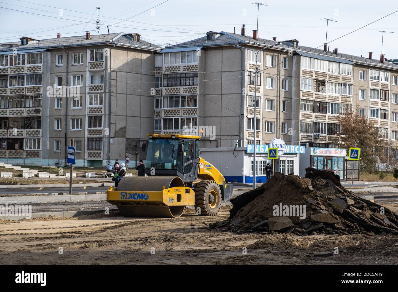 RUSSIA, ANGARSK - 17 ottobre 2020 costruzione, riparazione di una strada in una zona residenziale della città. Le attrezzature per la costruzione di strade compattano la strada. Foto Stock
