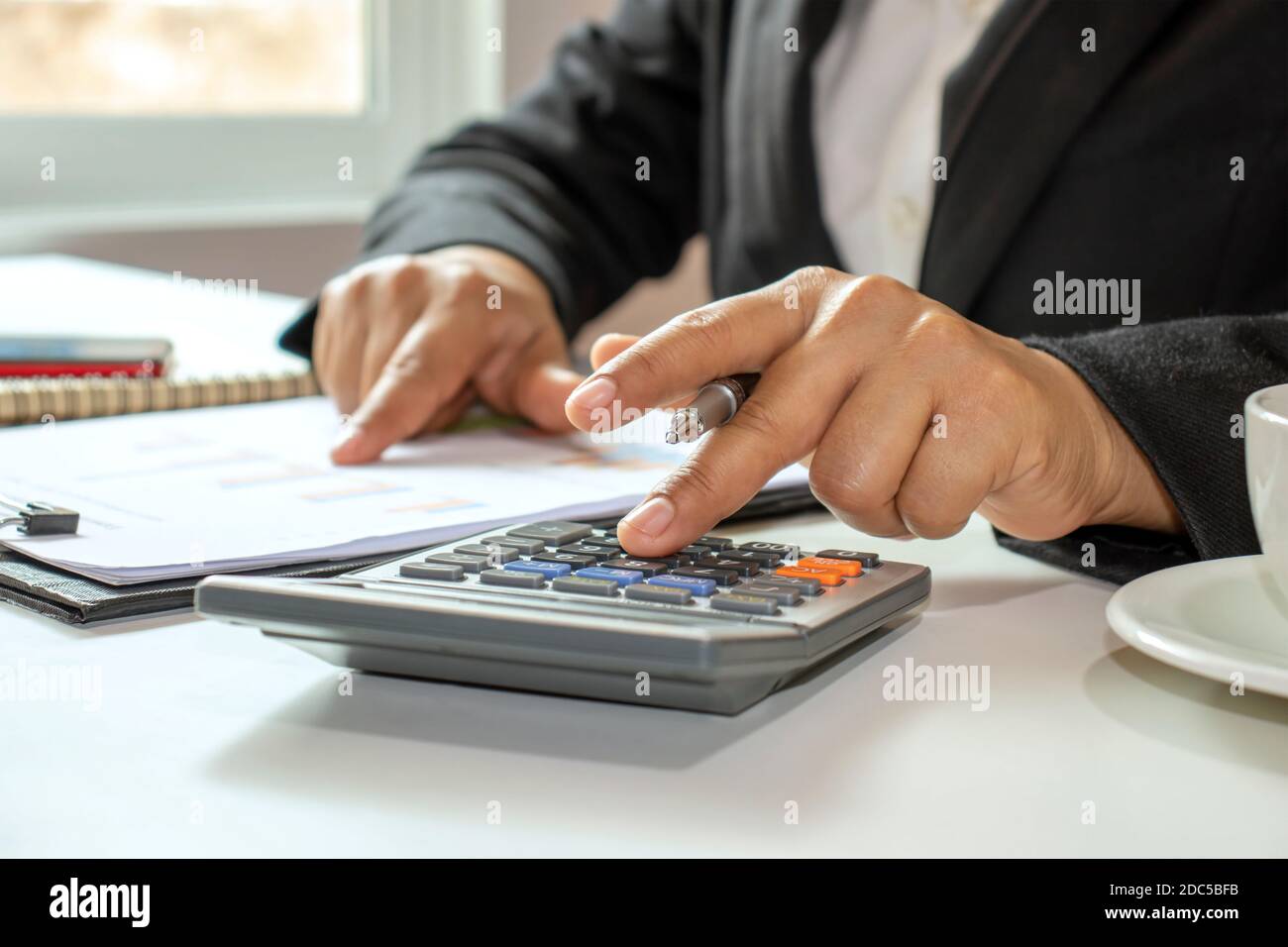 Idee di gestione per contabilità, finanza e manager che calcolano il loro reddito con una calcolatrice. Foto Stock