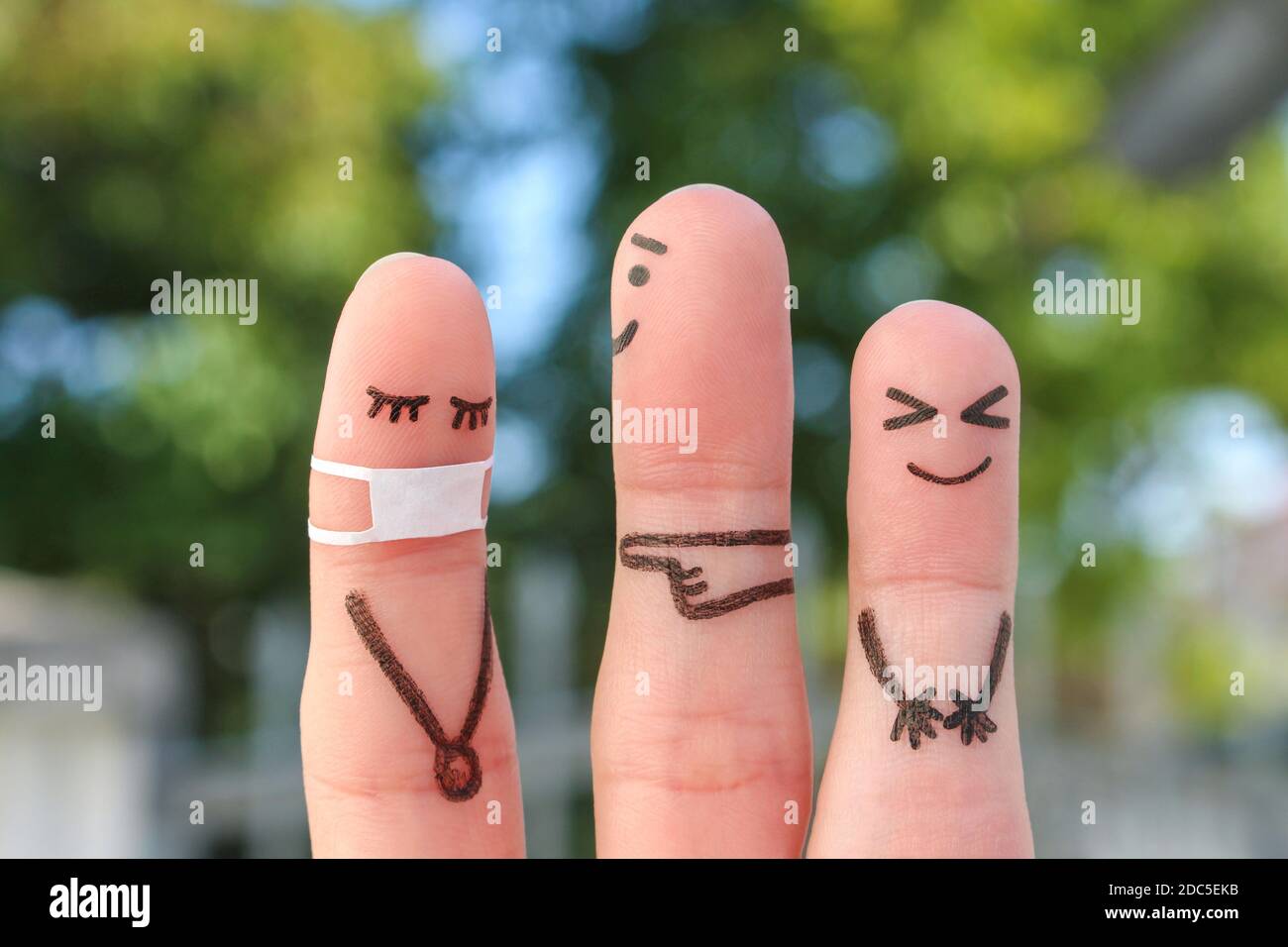 L'arte delle dita delle persone. Concetto bambini che bullono il loro compagno di classe in maschera medica da COVID-2019. Foto Stock
