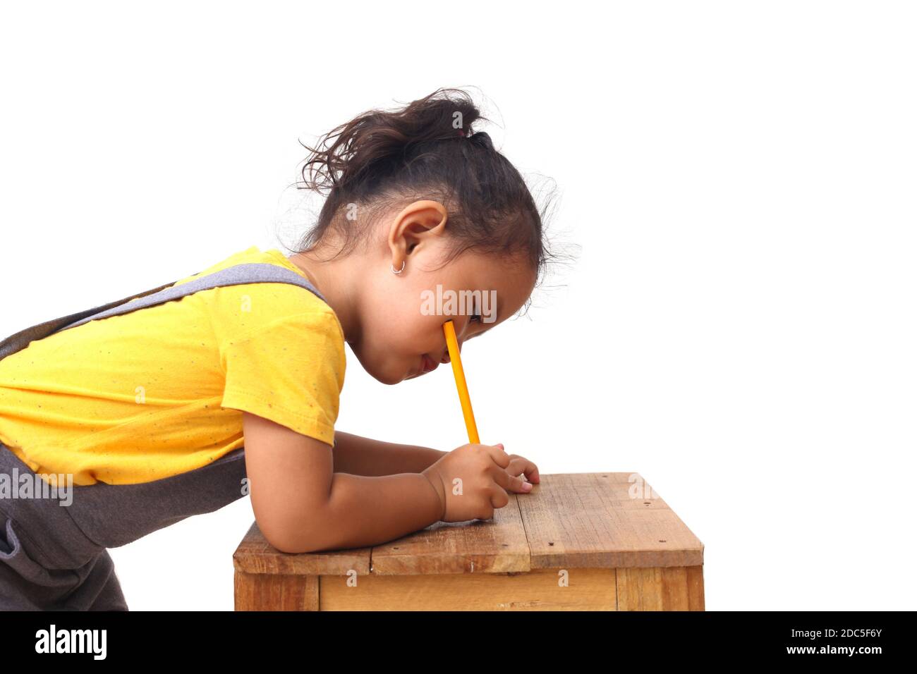 Adorabile ragazza asiatica imparare a scrivere. Isolato su sfondo bianco Foto Stock