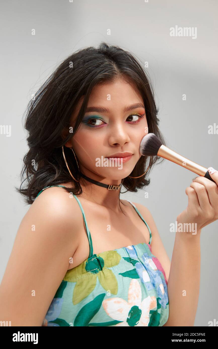 Bella Donna si applica il tono della pelle con la spazzola. Donna bella faccia. Perfetto trucco. Dermocosmesi Foundation. Pennelli trucco artisti Foto Stock