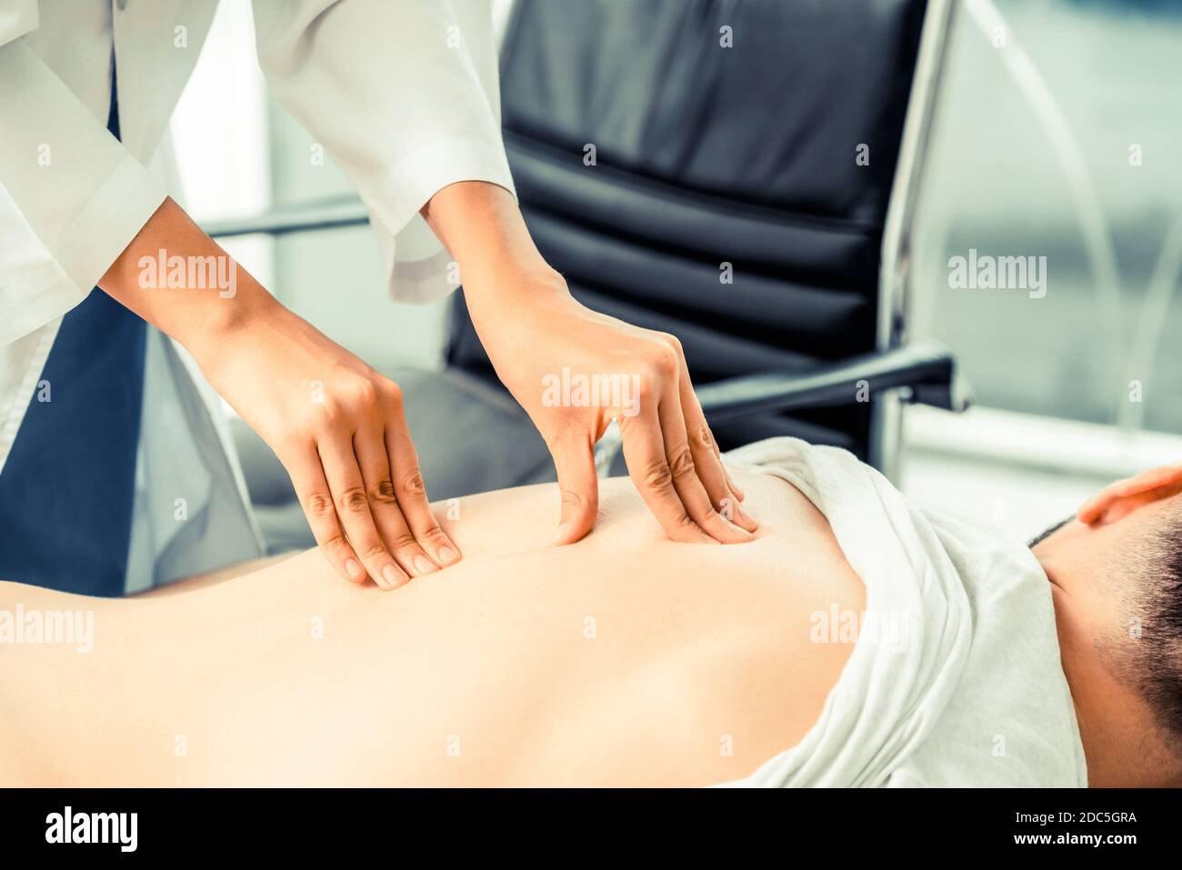 Donna medico sta esaminando il paziente di sesso maschile in ospedale in ufficio. Servizi sanitari e assistenza medica. Foto Stock