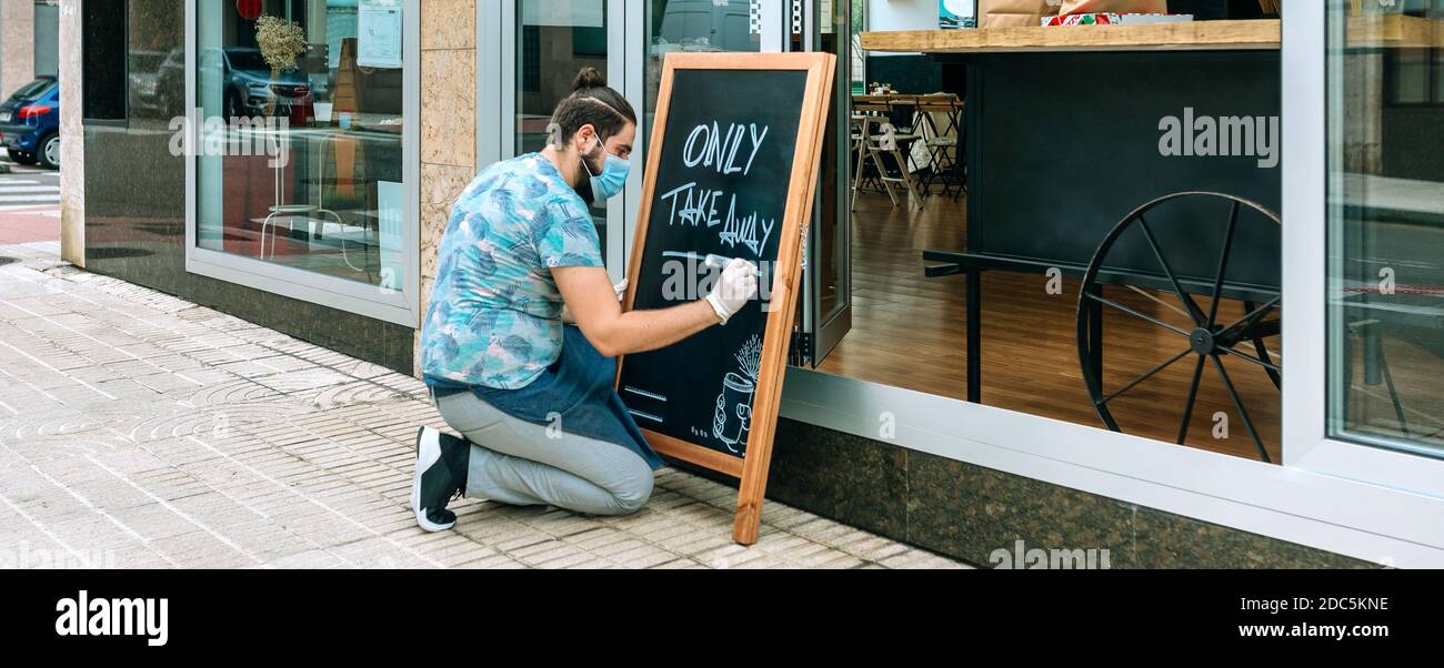 Il proprietario del ristorante scrive su una lavagna Foto Stock