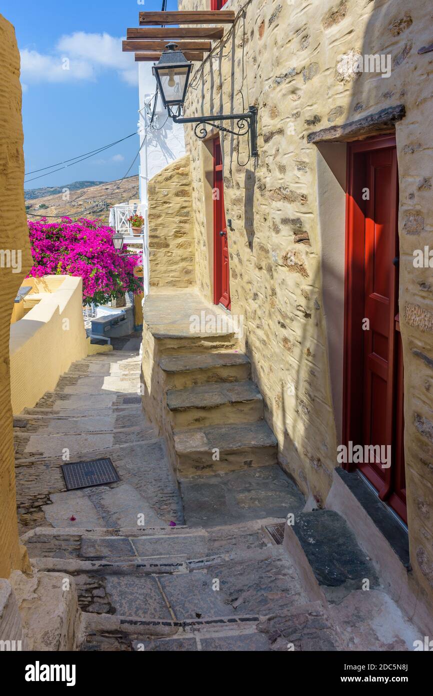 Tradizionale vicolo cicladico con stradine strette, case bianche e bouganvillea fiorente, in ano Syros Grecia Foto Stock