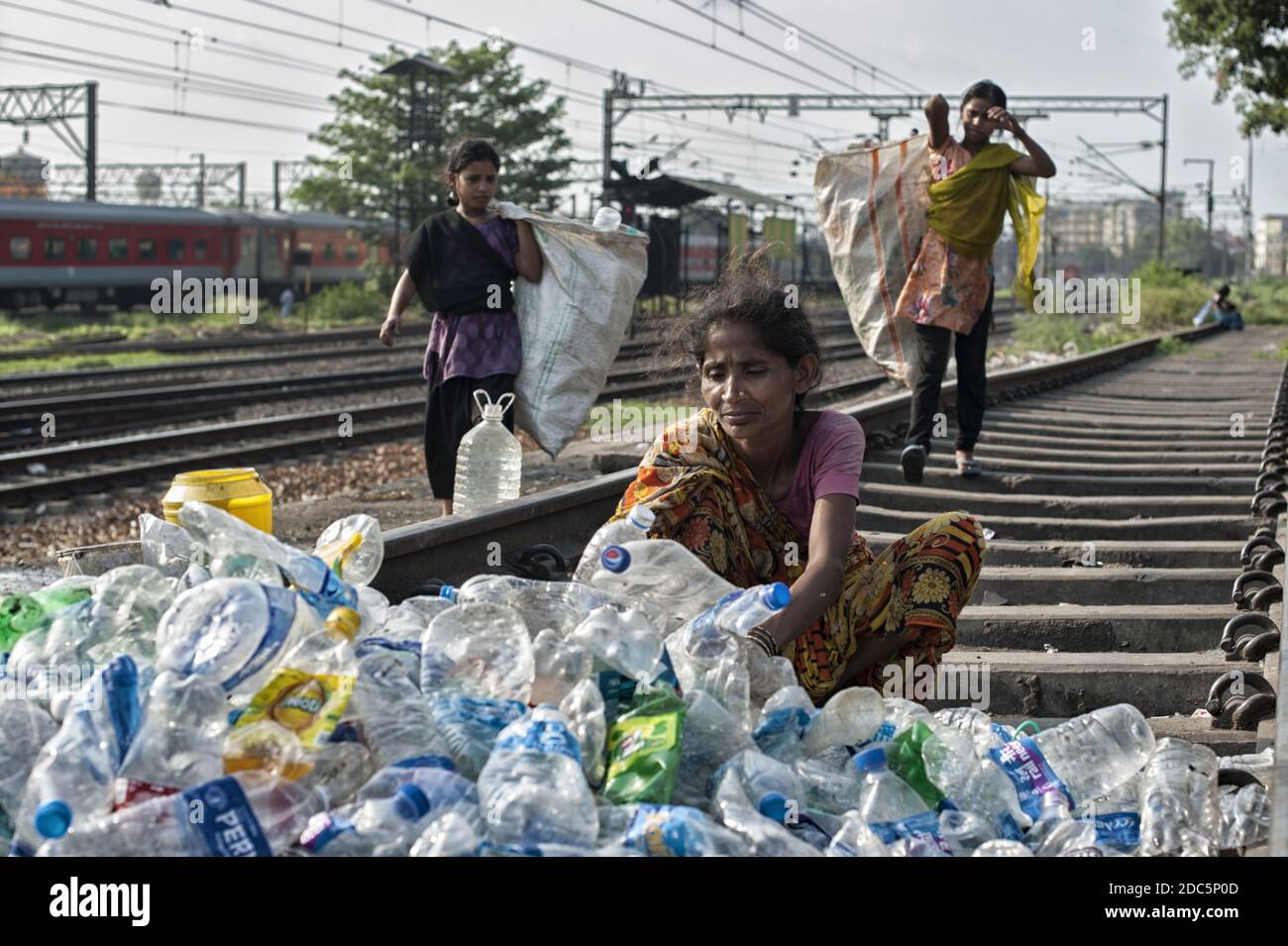 Una donna appartenente alla casta degli intoccabili (Dalit) seleziona bottiglie e altri contenitori di plastica raccolti nelle strade di Kolkata per la vendita. Foto Stock