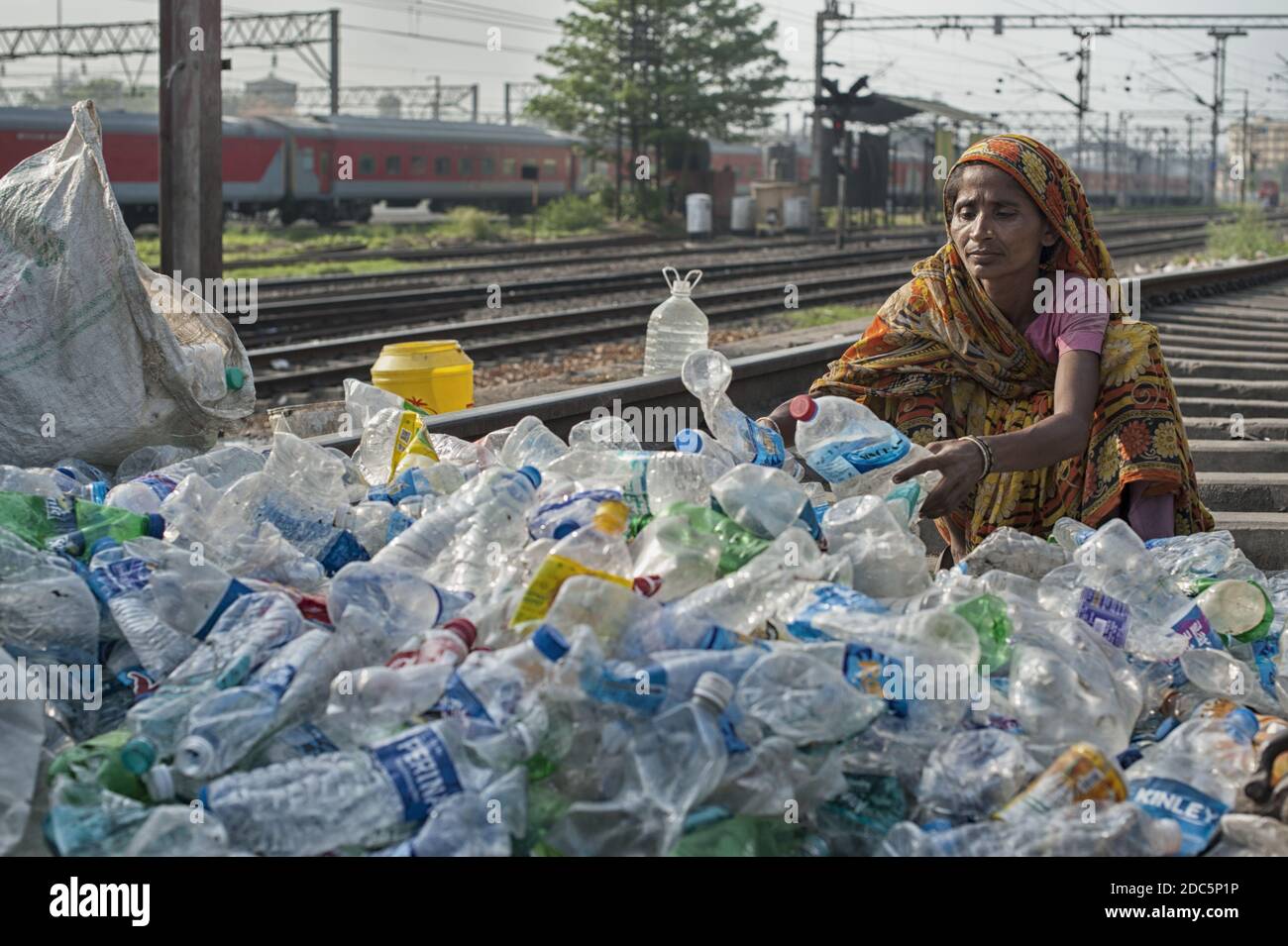 Una donna appartenente alla casta degli intoccabili (Dalit) seleziona bottiglie e altri contenitori di plastica raccolti nelle strade di Kolkata per la vendita. Foto Stock