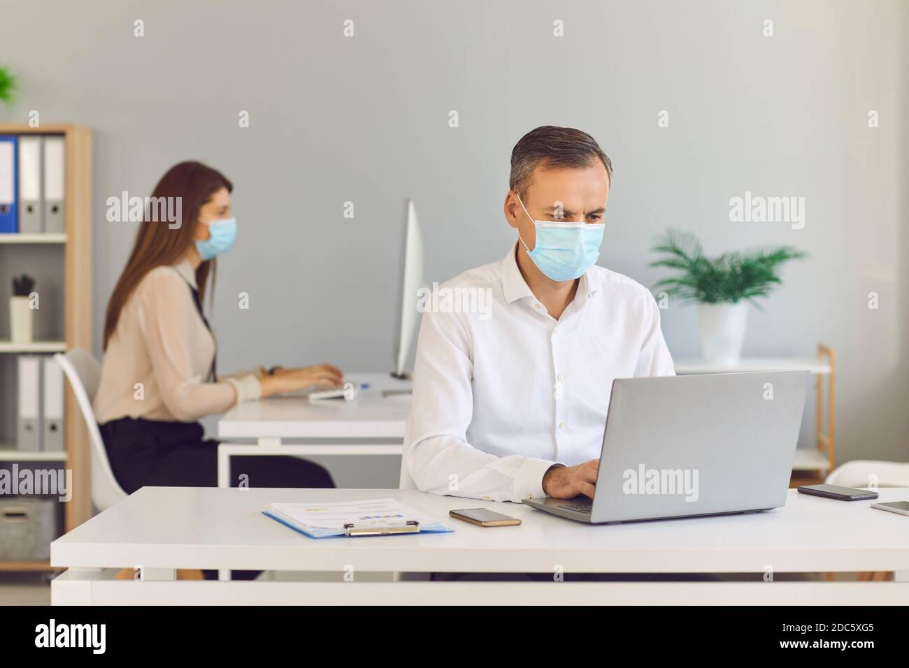 I dipendenti consapevoli indossano maschere per proteggere i propri clienti e prevenire la diffusione di COVID-19. Foto Stock