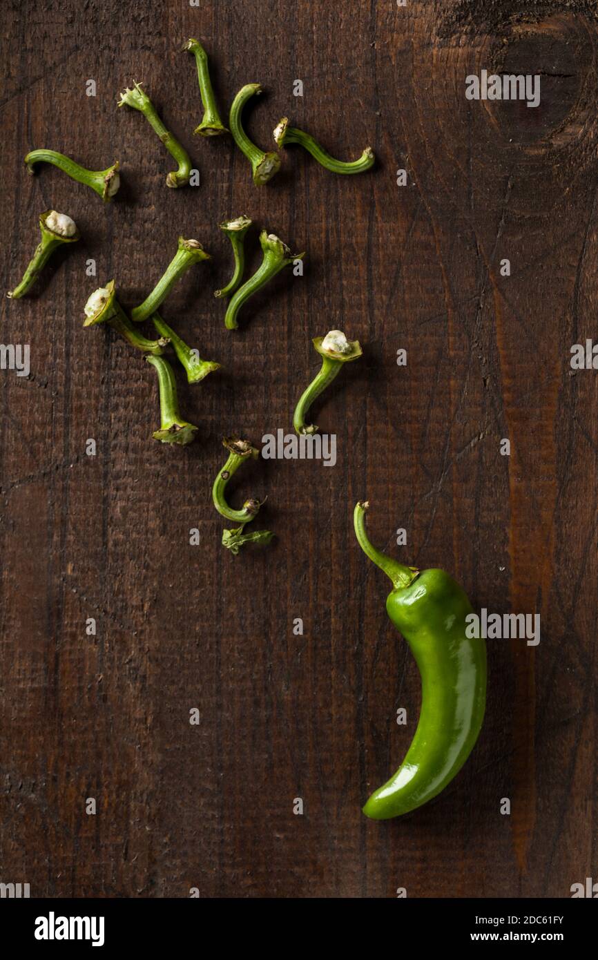 Peperoncino Friggitello verde con petoli scattarati su superficie di legno Foto Stock
