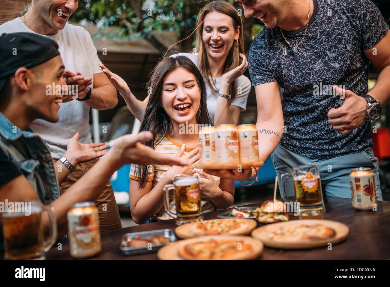 Party birra con gli amici bere birra Ganzberg e tostare birra presso il bar ristorante birreria. Concetto di amicizia con i giovani che si divertono insieme. Foto Stock