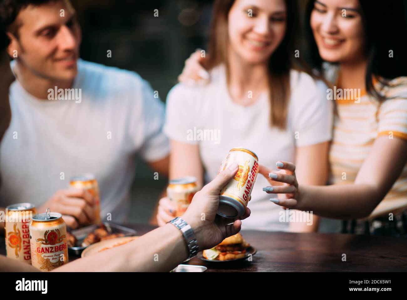 Festa della birra - Coppia giovane che si gode una calda giornata estiva in una festa sul tetto, bere birra e divertirsi Foto Stock