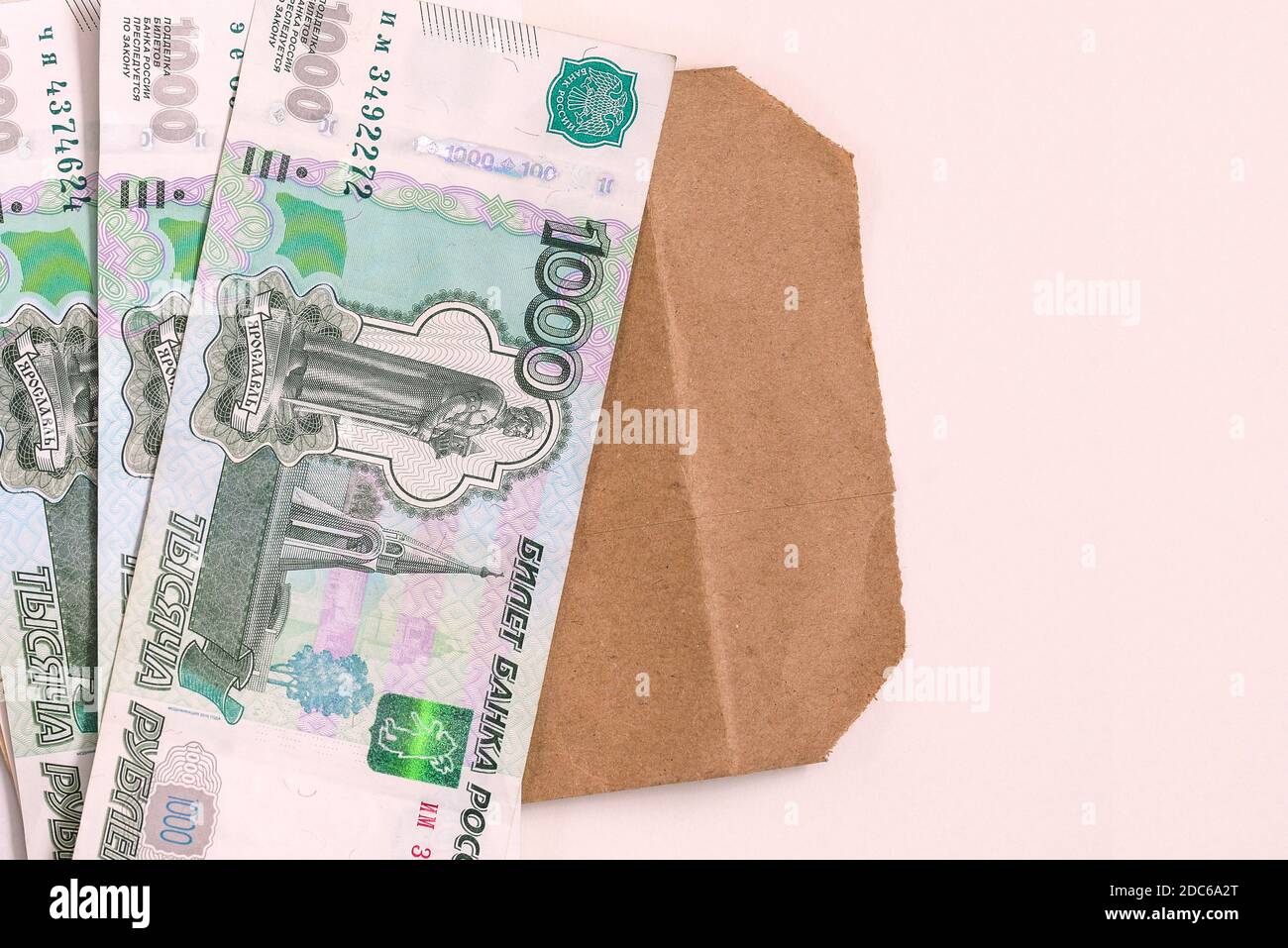 Denaro Russia. Una pila di contanti e una busta su sfondo bianco. Il concetto di stipendio in una busta. Profitti illegali Foto Stock